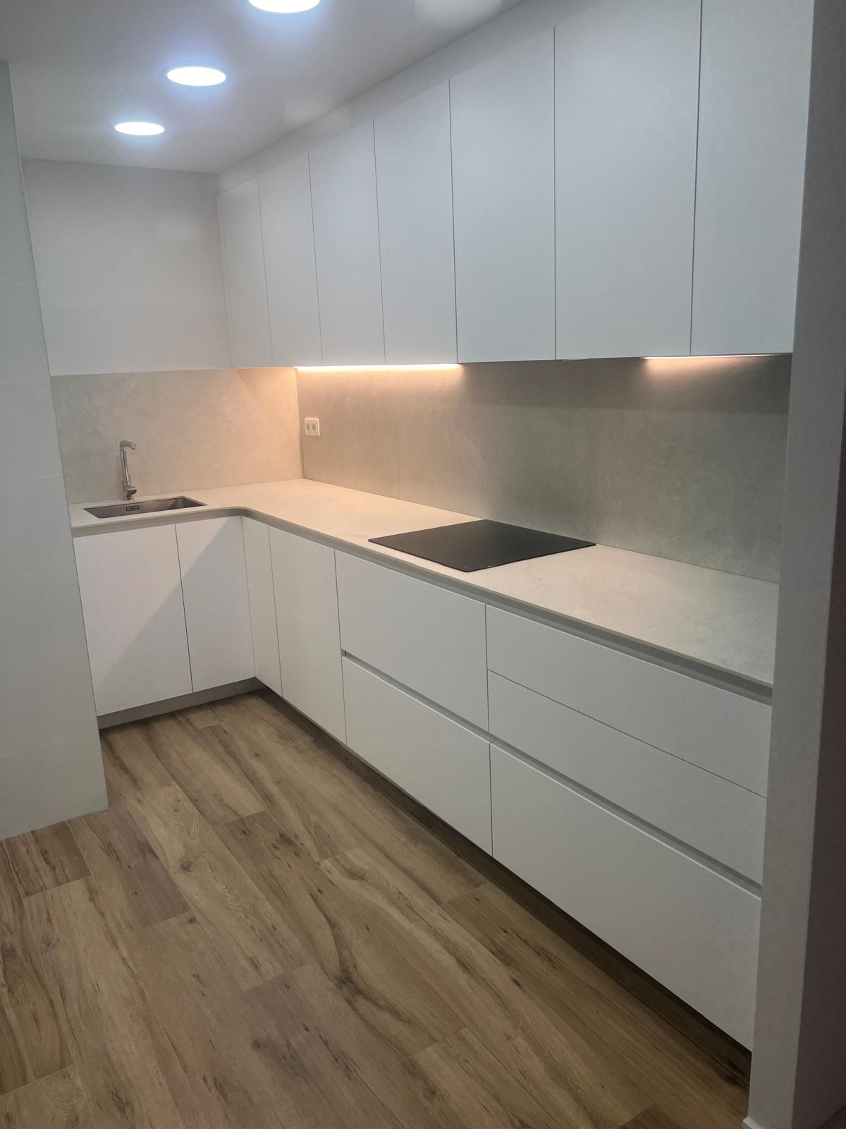 Proyecto de construcción con planos técnicos, escalímetro y calculadora sobre una mesa de trabajo en Madrid